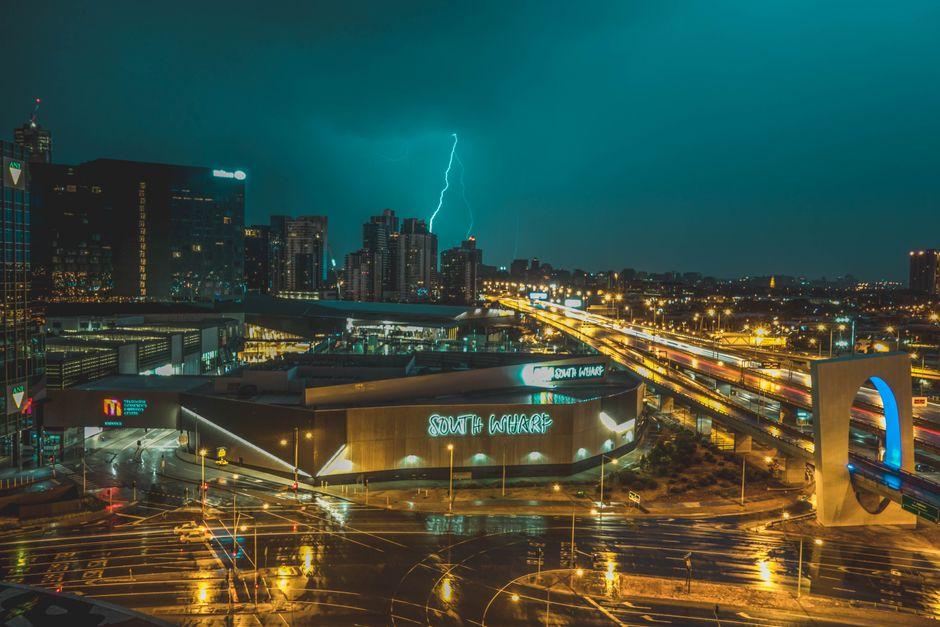 Bird S Eye View of Grey Building near Road and Thunder Lighting Strike in Background